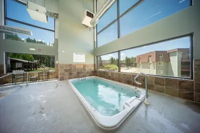 a large bath tub in a room with windows at Hi Country Haus Unit 1618 in Winter Park
