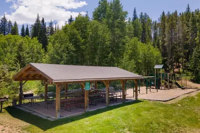 a pavilion with tables and benches in a park at Hi Country Haus Unit 2111 in Winter Park