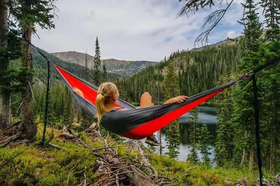 a woman laying in a hammock near a lake at Lake View Condo: Walk To Downtown/Lake Dillon in Dillon