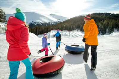 a group of people standing in the snow with tubing at Silver Mill 8260 - 2Br-Walk to Slopes! Kids Ski Free! condo in Keystone